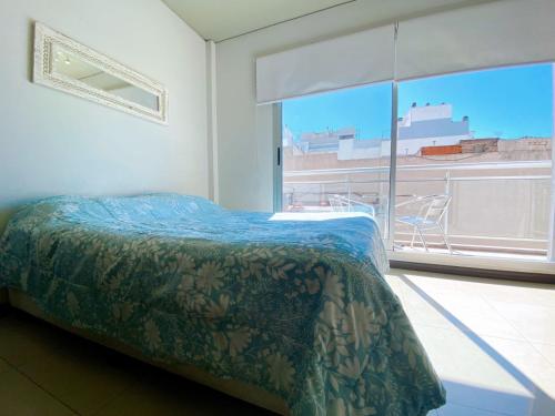a bedroom with a bed and a large window at Roosevelt 1681 in Buenos Aires