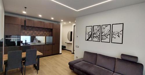 a living room and kitchen with a couch and a table at Birštono Perlas apartamentai in Birštonas