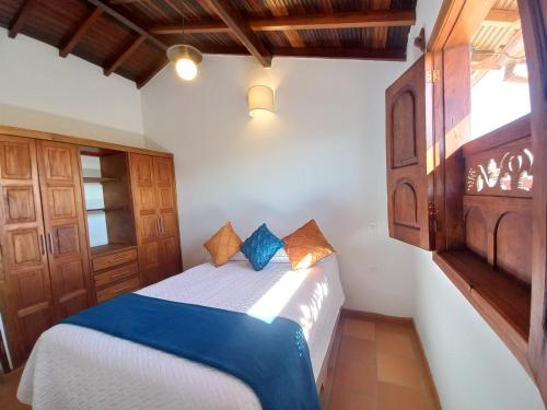 1 dormitorio con 1 cama con sábanas azules y blancas en Hermosa y Acogedora Casa de Descanso & Mirador, en Barichara