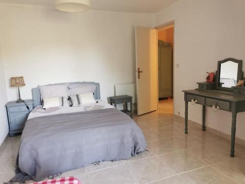 1 dormitorio con cama, mesa y espejo en Rez de villa pour 4 personnes, en Trets