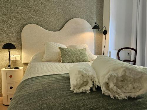 a bedroom with a large bed with white sheets and pillows at Apartamento Vetalegua Jerez in Jerez de la Frontera