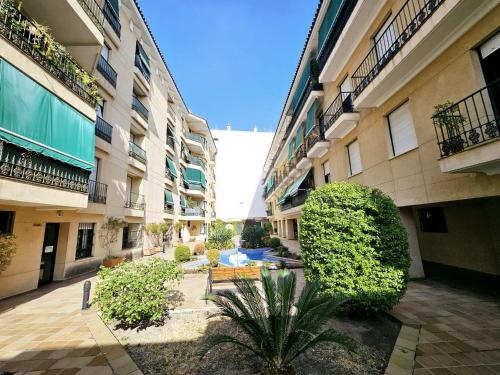 an empty courtyard of an apartment building with bushes at Apartamento Vetalegua Jerez in Jerez de la Frontera
