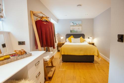 a bedroom with a bed and a dresser and a mirror at 1 Castle Mews in Dartmouth