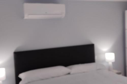 Un dormitorio blanco con una cama y dos lámparas. en 'A Tanheira' bedroom in The Cliff Coast Accomodation, en Paul do Mar