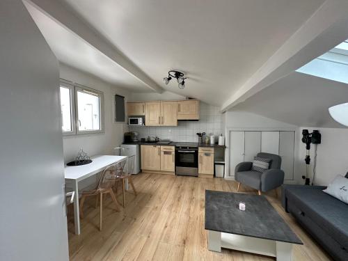 une cuisine et un salon avec un canapé et une table dans l'établissement Un cocon climatisé au bord du Lac d’Hossegor, à Soorts-Hossegor