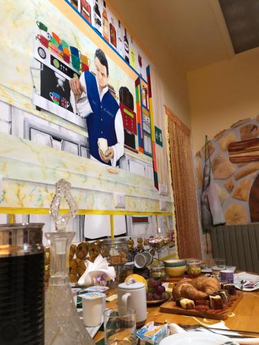 a kitchen with a table with food and art on the wall at La Vista in Calitri