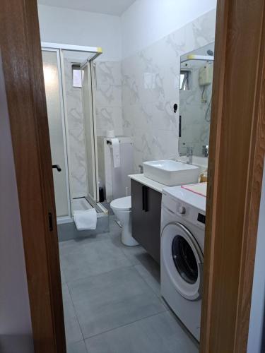 a bathroom with a washing machine and a sink at Plein Soleil in Grand Baie