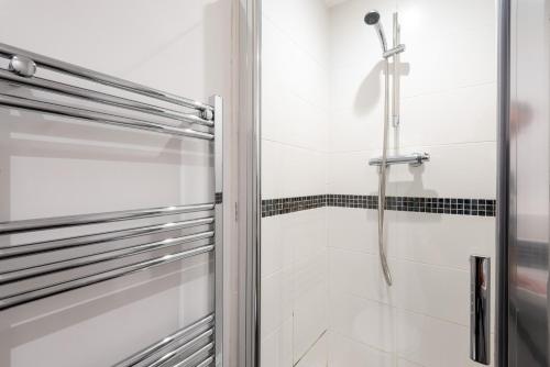 y baño con ducha y puerta de cristal. en A beautiful serviced home with parking and garden, Derby en Derby