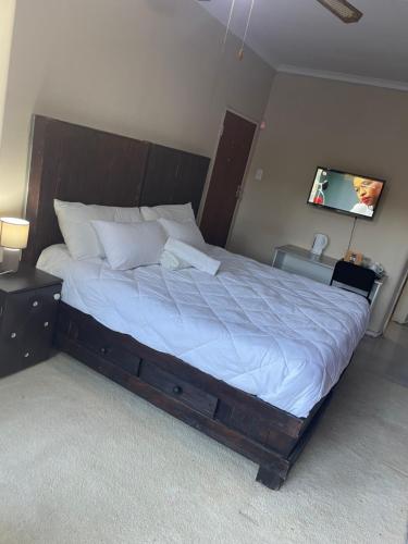 a large bed in a bedroom with a tv on the wall at SapzRes at Klerksdorp in Klerksdorp