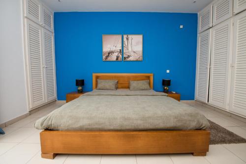 a blue bedroom with a large bed with blue walls at Duplex moderne avec vue exceptionnelle sur la mer in Pointe-Noire