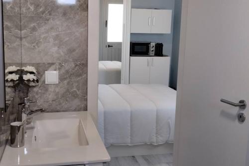 a bathroom with a bed and a sink and a mirror at 'A Bucha' by The Cliff Coast in Paul do Mar