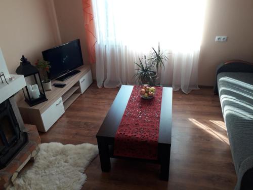 a living room with a coffee table and a television at Brīvdienu māja"Ordziņas' in Pāvilosta