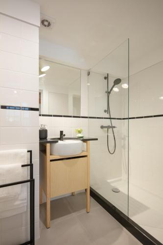 a bathroom with a sink and a shower at Gateway House Studio Apartments in Guimarães