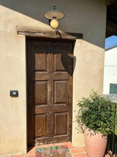 a wooden door on a building with a potted plant at Casa Nonna Ada in Cisterna dʼAsti