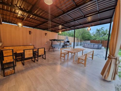 a covered patio with tables and chairs and a piano at New Horizons , villa with 5 bedrooms, whole apartment, апартмент целиком in Dilijan