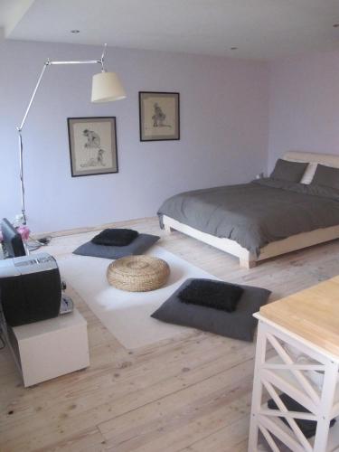a bedroom with a bed and some rugs on the floor at Liepaja Pine Apartment in Liepāja