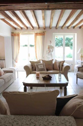 a living room with a couch and a table at Chambres à la maison Hermitage in Aincourt