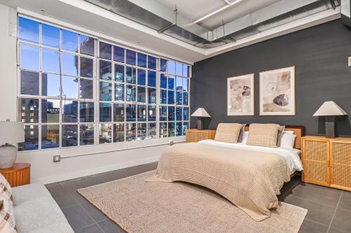 een slaapkamer met een groot bed en grote ramen bij Sunny & Spacious 2BDR & 1BTH in Downtown LA in Los Angeles