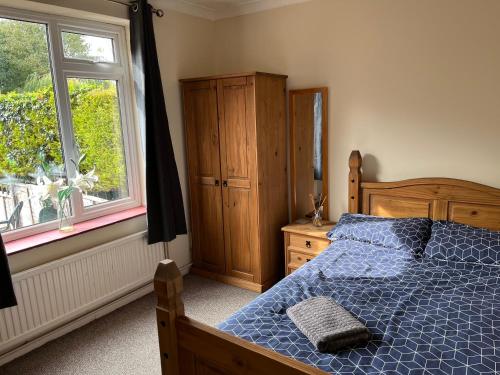 um quarto com uma cama azul e uma janela em Large 7 double bedroom house with large driveway em Earlham