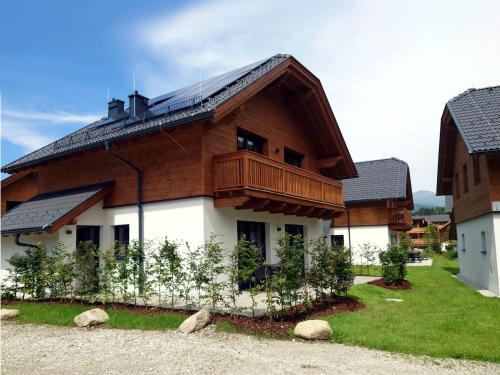 a house with a wooden roof and a balcony at AlpiNest Feriendorf Lungau in Mariapfarr