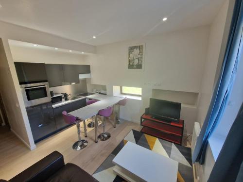 a kitchen and living room with a table and chairs at Le Keyla -10mn Genève-4 Pers-Cosy-Parking privé in Contamine-sur-Arve