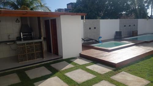 a backyard with a deck and a swimming pool at POUSADINHA LITORAL in Mucuri