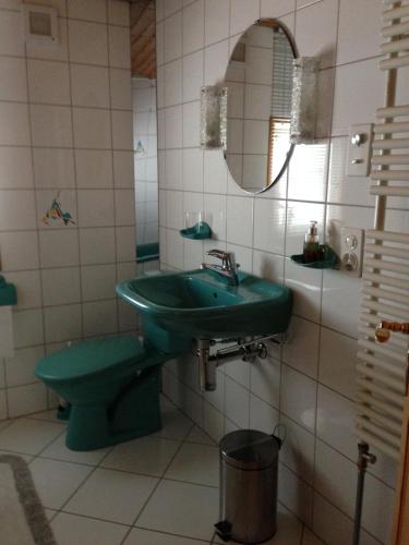 a bathroom with a green sink and a mirror at Ferienhaus Rütiweid in Appenzell