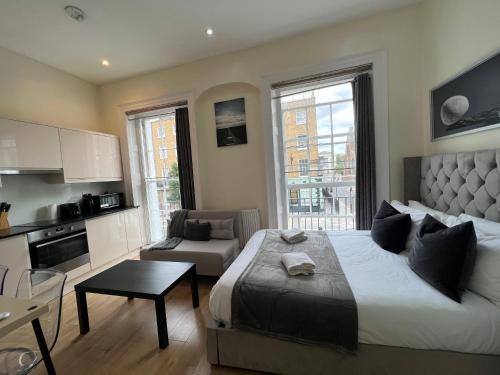 a bedroom with a large bed and a kitchen at Gloucester Place - Baker Street in London