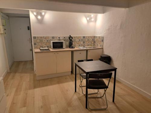a small kitchen with a table and a microwave at 183 studio proche opéra in Toulon