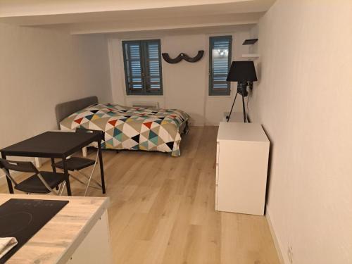 a bedroom with a bed and a table in a room at 183 studio proche opéra in Toulon