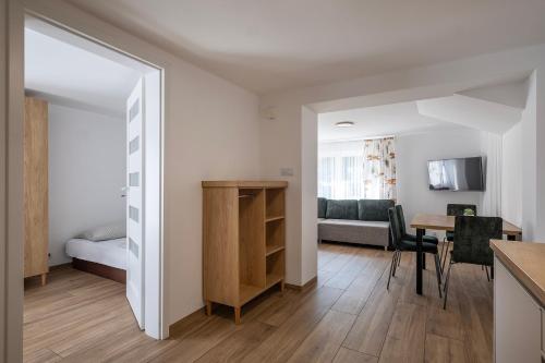 a living room with a kitchen and a dining room at 4 Pory Roku Apartamenty Domki Pokoje in Nadole