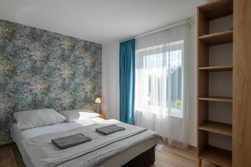a bedroom with a bed and a window at 4 Pory Roku Apartamenty Domki Pokoje in Nadole