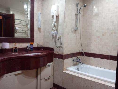 y baño con lavabo, bañera y ducha. en LUXURY HOTEL APARTMENT RENTAL en Alexandría