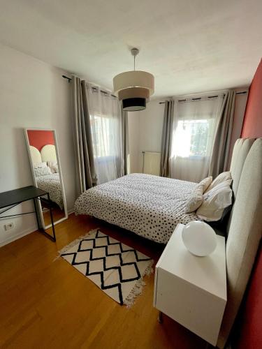 a bedroom with a bed and a couch and a table at Le Duplex Paris Basilique Stade de France in Saint-Denis