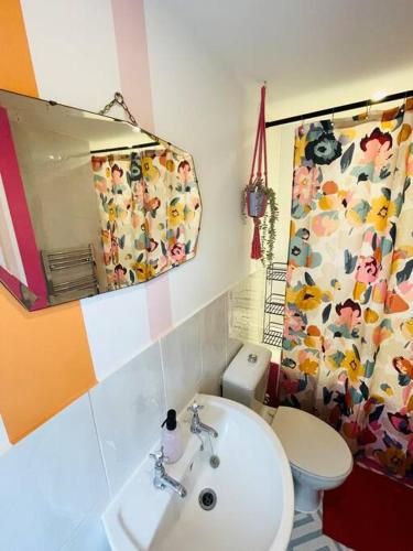 a bathroom with a toilet and a sink and a mirror at Colourful Apartment in Margate in Kent