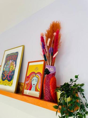 a shelf with two pictures and a vase on it at Colourful Apartment in Margate in Kent