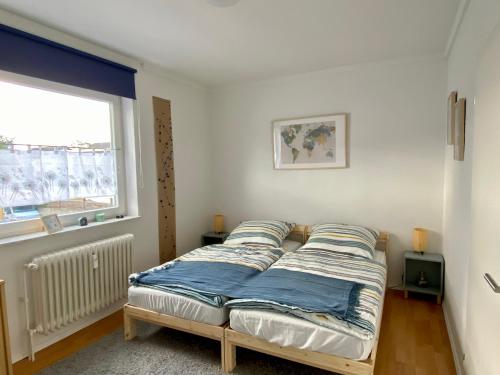 a bed in a room with a window at Die 2eitwohnung in Hochheim am Main