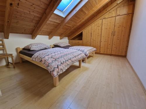 two beds in a room with wooden cabinets at Ruhige Lage schnelles Internet 100 Mbits Netflix LG TV 4K 55" Bosch Waschmaschinen und Wäschetrockner in Waging am See