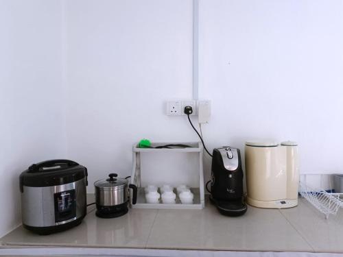 a kitchen counter with several appliances on a counter top at YK Homestay in Kulai