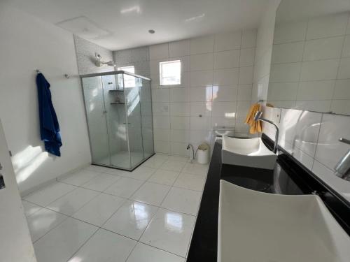 a bathroom with a shower and a sink and a toilet at Casa de praia no Hibiscus Beach Clube, Condomínio Angras de Ipioca. in Maceió