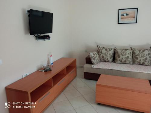 a living room with a couch and a tv at APARTMANI LUX SEA in Utjeha