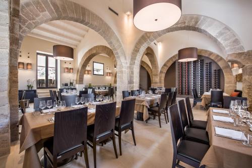 a restaurant with wooden tables and chairs and brick walls at Firriato Hospitality - Baglio Sorìa in Trapani