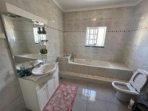 La salle de bains est pourvue d'un lavabo, d'une baignoire et de toilettes. dans l'établissement Victoria Superb Rooms, à Arrentela