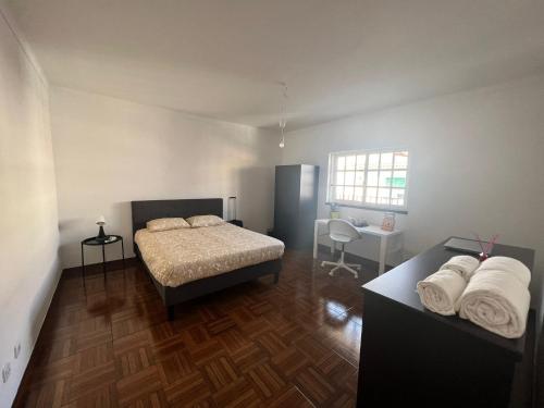 1 Schlafzimmer mit 2 Betten, einem Schreibtisch und einem Fenster in der Unterkunft Victoria Superb Rooms in Arrentela