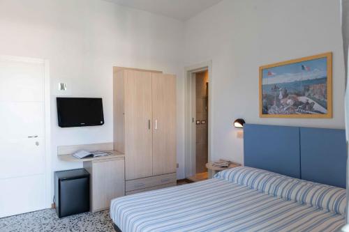 切爾維亞的住宿－Hotel Smart Cervia，一间卧室配有一张床、一个橱柜和一台电视