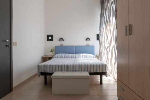 a bedroom with a bed with a blue headboard at Hotel Smart Cervia B&B in Cervia