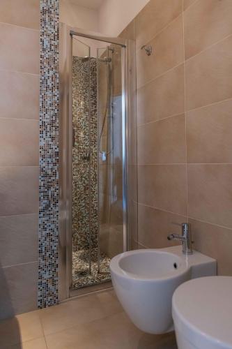 a bathroom with a shower and a toilet and a sink at Hotel Smart Cervia B&B in Cervia
