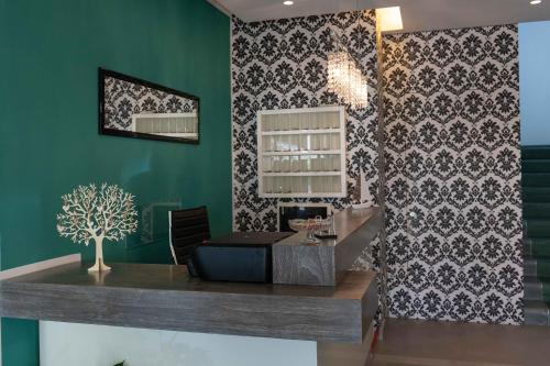a bar with a green wall with a black and white wallpaper at Hotel Smart Cervia B&B in Cervia