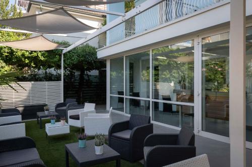 a patio with chairs and tables and an umbrella at Hotel Smart Cervia B&B in Cervia