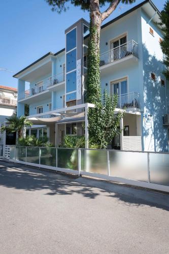 an apartment building with a fence in front of it at Hotel Smart Cervia B&B in Cervia